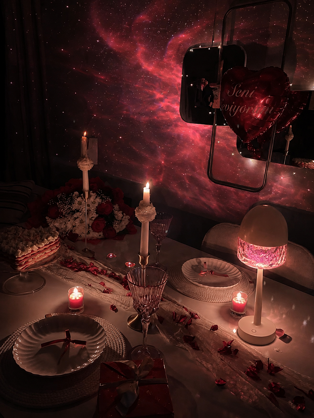 Table dressée pour un dîner romantique, éclairée par la projection LYNOVAIR ONE rouge nébuleuse